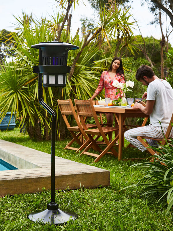 Lampe anti-moustiques Tiger Trap Pro placée dans un jardin au bord de la piscine