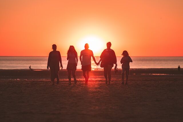 Groupe de personnes sur la plage au coucher de soleil